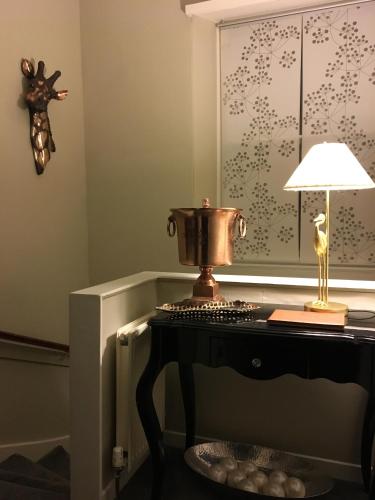 a table with a lamp and a trophy on it at Apartment 28 in Ayr