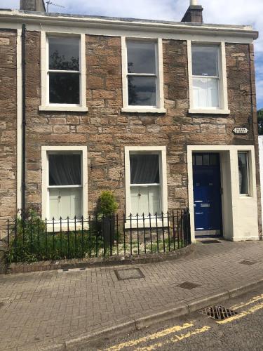 a brick house with a fence in front of it at Apartment 28 in Ayr