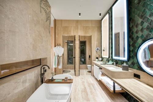 a large bathroom with a tub and a sink at Regnum The Crown in Belek