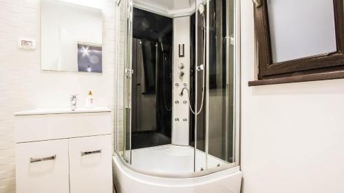ein Badezimmer mit Dusche und Waschbecken in der Unterkunft Panoramic de lux Mihai Bravu cu internet de mare viteza si parcare gratuit in Bukarest