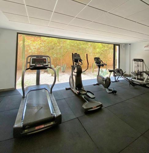 a gym with several exercise bikes and a large window at Luxury Palm Villa in Marrakech