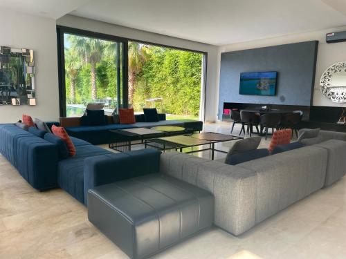 a living room with blue couches and a table at Luxury Palm Villa in Marrakech