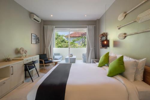 a bedroom with a large bed with green pillows at Villa Levi by GORO in Seminyak