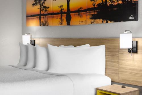 a bedroom with a bed and a painting on the wall at Days Inn by Wyndham Waycross in Waycross
