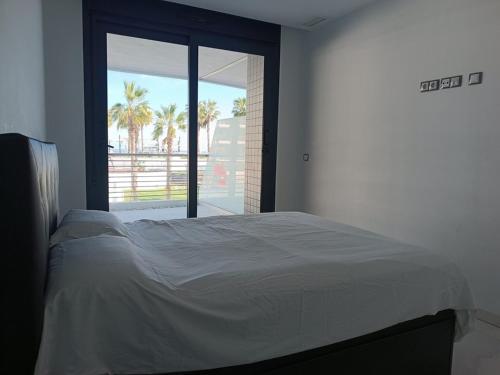 une chambre avec un lit et une grande fenêtre dans l'établissement Moderno apartamento con terraza y vistas al mar R22 by Novadesta, à Arenales del Sol