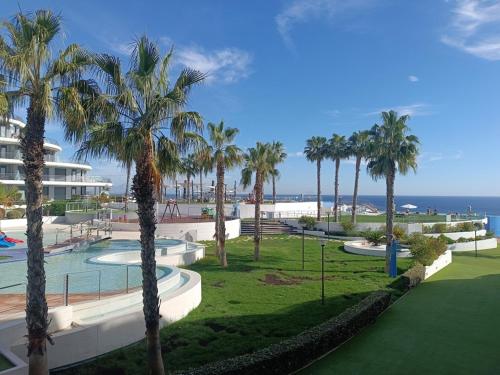 un complexe avec des palmiers et une piscine dans l'établissement Moderno apartamento con terraza y vistas al mar R22 by Novadesta, à Arenales del Sol