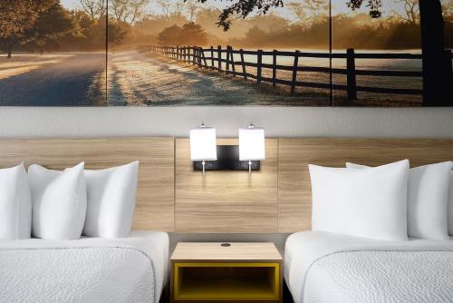 a room with two beds and a fence at Days Inn by Wyndham Waycross in Waycross