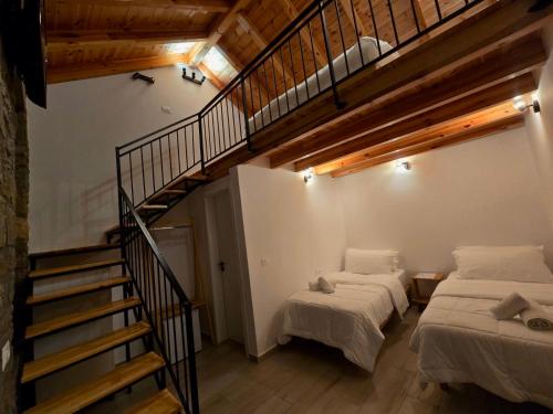 two beds in a room with a staircase at Gogo Moustache Guest House in Përmet