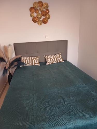 une chambre avec un lit avec une couette verte dans l'établissement Mandelieu la Napoule, à Mandelieu-la-Napoule