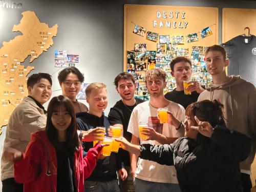 a group of people holding up glasses of orange juice at Xi'an Desti Youth Park Hostel Bell & Drum Tower in Xi'an