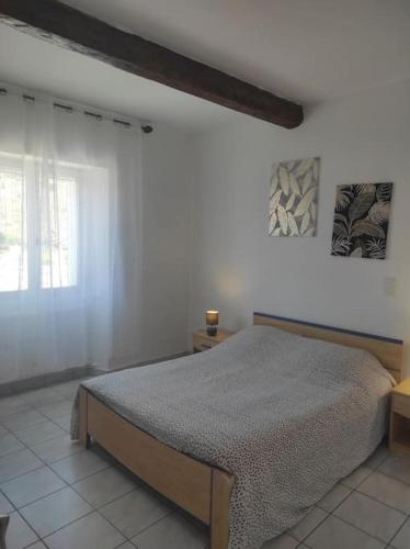 une chambre avec un lit dans une pièce blanche dans l'établissement Haut de maison à Nyons, à Nyons