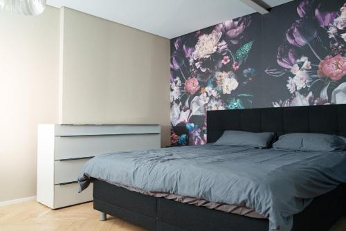 a bedroom with a large bed with a floral wallpaper at Luxuriöse Maisonette Oase mit Panoramablick in Stuttgart