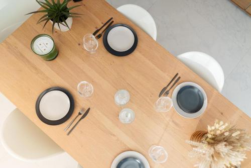 a wooden table with wine glasses and a clock on it at Luxuriöse Maisonette Oase mit Panoramablick in Stuttgart