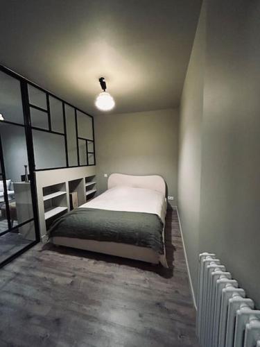 une chambre avec un lit dans le coin d'une pièce dans l'établissement Appartement art deco Reims, à Reims