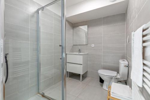 a bathroom with a toilet and a glass shower at L'Escapade Paris in Le Kremlin-Bicêtre