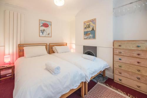 萨克斯曼德姆Lower Cedars, Saxmundham的一间卧室配有一张床、梳妆台和一张床