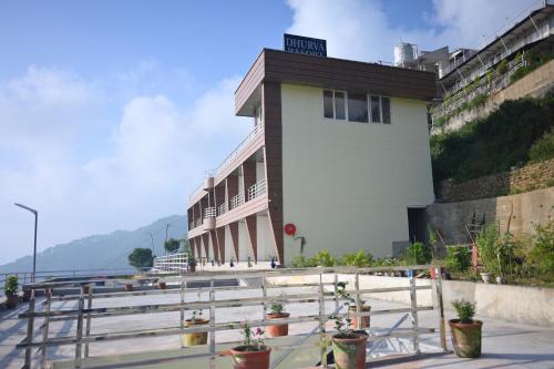 a building with potted plants in front of it at Dhurva Hotel and Resort in Naugaon