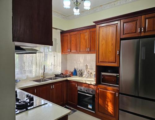 a kitchen with wooden cabinets and a stainless steel refrigerator at Blue Rawal in Bain Boeuf