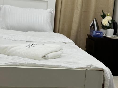 a bed with white sheets and towels on it at Amazing Sea View Stay Abu Dhabi in Abu Dhabi