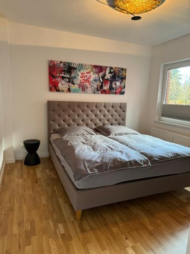a bedroom with a bed with a headboard and a window at Duvenstedter Rotklinker in Hamburg