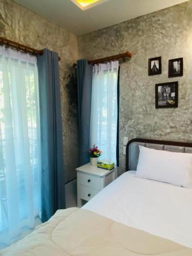 a bedroom with a white bed and two windows at Kuba Bungalows in Ko Kood