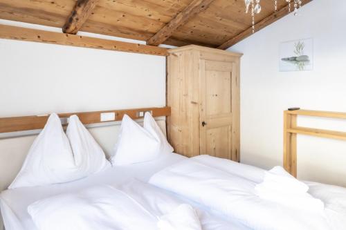 a bedroom with white bedding and a wooden ceiling at URALP Royal in Brand