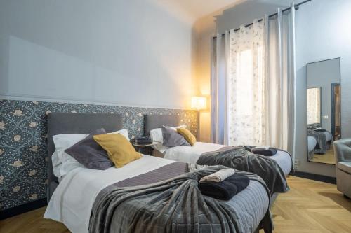 sypialnia z dwoma łóżkami i lustrem w obiekcie TORNABUONI APARTMENT - in OLD TOWN center FIRENZE we Florencji