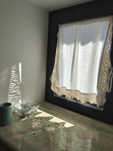 a window with a curtain on a table in a room at Numero 33 in Cori