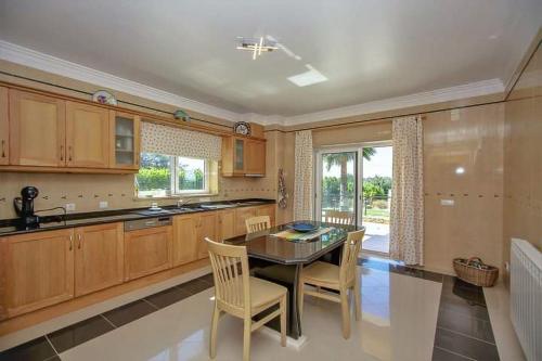 a large kitchen with a table and chairs in it at Quinta do Sol in Guia