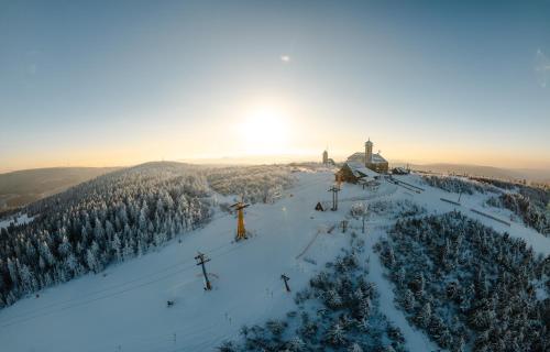 a snow covered ski slope with a ski lift at Fichtelberghaus in Kurort Oberwiesenthal