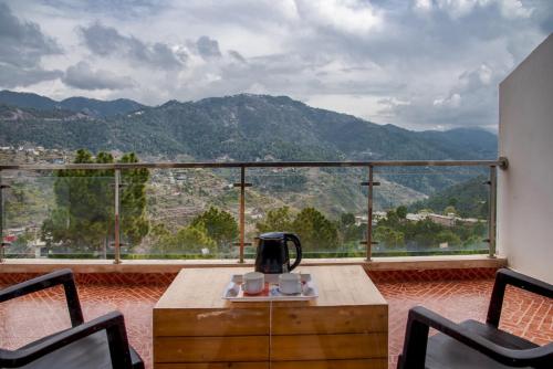 a room with a table and chairs and a large window at Exotic Stays I 2 BHK Serviced Apartments I Mountain View I The Western Heights I Kasauli in Kasauli