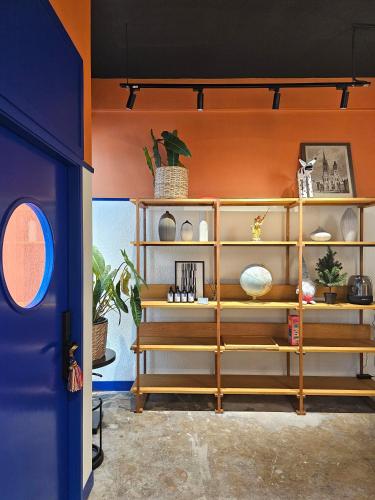 a room with orange walls and shelves with vases at Blu Dock Restel Bangkok in Bangkok
