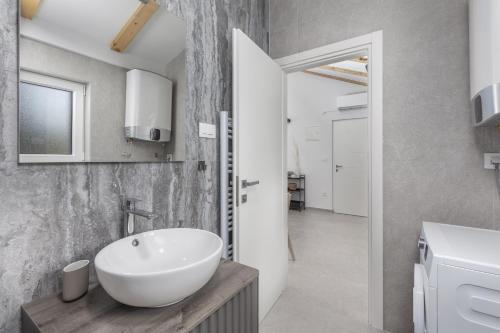 a bathroom with a white bowl sink in a room at Apartments White and Green in Malinska