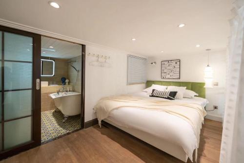 a bedroom with a bed and a tub and a sink at Tonight Homestay West Nanjing Road Shanghai in Shanghai