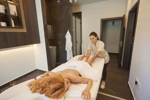 a woman laying on a bed in a room at The HEALTHY Stay-Padel, Pool&Fitness in Ayia Napa