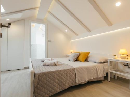 a white bedroom with a large bed with yellow pillows at Holiday Home Lozo by Interhome in Gornji Proložac