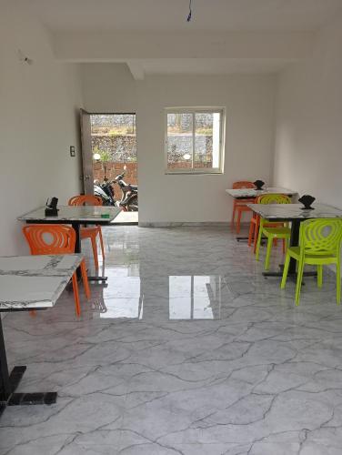 a room with tables and colorful chairs in it at Western Valley Cottages , Panchagani in Panchgani