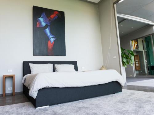 a bedroom with a bed with a painting on the wall at Phuket 4-Bedrooms Seaview 884m2 Private XL Luxury Infinity Pool Villa in Ban Pa Khlok