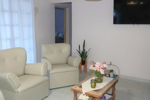 a living room with two chairs and a coffee table at Las Valentinas Hospedaje de Montaña in Chilecito