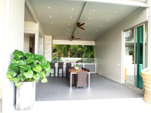 a patio with a table and a ceiling fan at Phuket 4-Bedrooms Seaview 884m2 Private XL Luxury Infinity Pool Villa in Ban Pa Khlok
