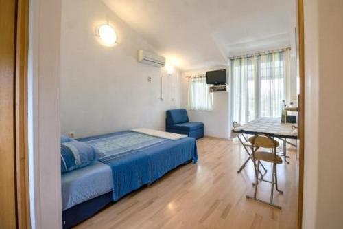 una camera da letto con un letto, un tavolo e una sedia di Ferienwohnung in Luka mit Meerblick, Terrasse, Klimaanlage, W-LAN 4659-2 a Luka