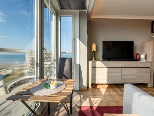 ein Wohnzimmer mit Tisch und Fernseher in der Unterkunft Apartment Ravenna by Interhome in Middelkerke