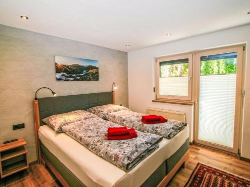a bedroom with a bed with red pillows on it at Apartment Stöckl by Interhome in Schwendau