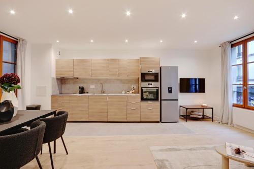 une cuisine avec des armoires en bois et un réfrigérateur dans l'établissement Boutiques Apartments Paris, à Paris
