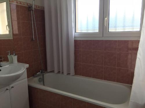 une salle de bain avec une baignoire et un lavabo dans l'établissement Bassin d'Arcachon Maison au calme, à Gujan-Mestras