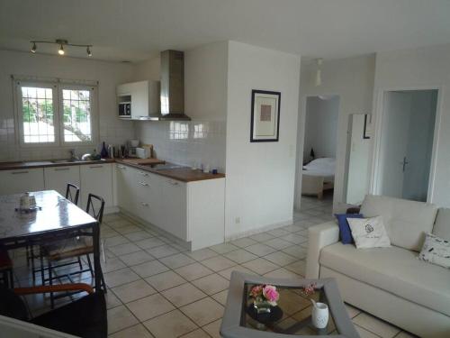 Il dispose d'une cuisine et d'un salon avec un canapé et une table. dans l'établissement Bassin d'Arcachon Maison au calme, à Gujan-Mestras