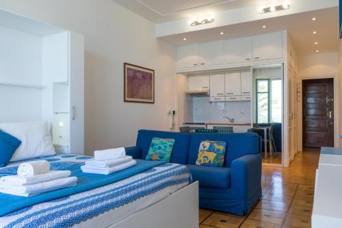 un salon avec un canapé bleu et une cuisine dans l'établissement Promenade 2 Pers Vista Mare WiFi AC, à Nice