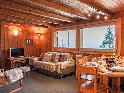 a living room with a couch and a desk and a television at Chalet Chalet Grepon by Interhome in Saclentse