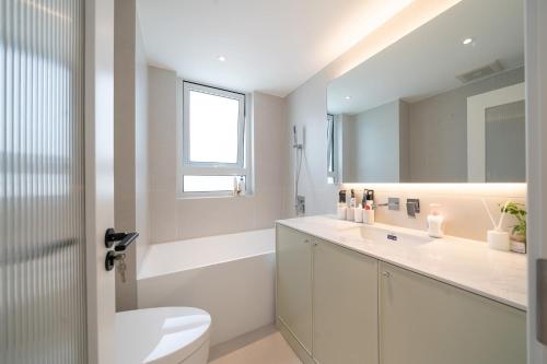 a white bathroom with a toilet and a sink at Tonight Homestay West Nanjing Road Shanghai in Shanghai