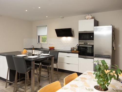 une cuisine avec une table et des placards blancs dans l'établissement Holiday Home Clos Miroir by Interhome, à Cancale